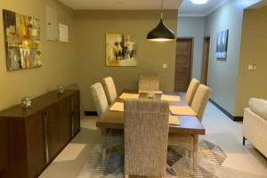达累斯萨拉姆Grany Apartment - Palm Village的一间带木桌和椅子的用餐室