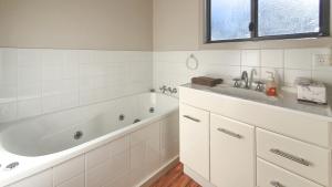 Barnes Bay布鲁尼艾奇达纳度假屋的白色的浴室设有浴缸和水槽。