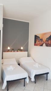 帕代诺杜尼亚诺BNBOOK - Green Zone Studio的一间设有两张床的客房,墙上挂着一幅画