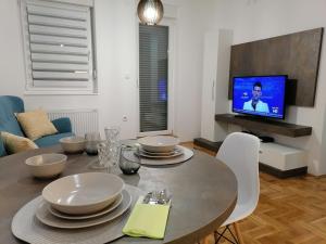 诺维萨德Carmen deluxe的一间带桌子和电视的用餐室