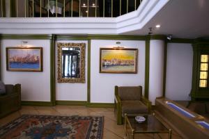 伊斯坦布尔伊斯坦布尔皇家酒店的一间挂有壁画和椅子的等候室