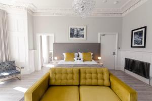 马瑟韦尔Sweeney Apartments & Rooms的一间卧室配有一张床和一张黄色的沙发