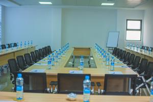 卢萨卡Asmara Hotel的一间会议室,配有一张长桌和瓶装水