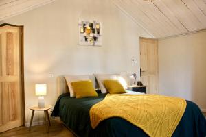 维厄勒斯Le Clos Vitis的一间卧室配有一张带两个黄色枕头的床