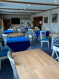 卡迪根Flambards Hotel的一间配备有桌子和蓝色椅子的用餐室
