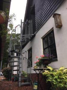 EenrumT’ Hogeland Ainrom的一座黑白房子,有楼梯和鲜花