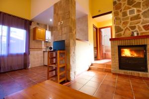 比利亚尔瓦德拉谢拉Aventura & Relax Cabañas Peña la Higuera的带壁炉的客厅和厨房
