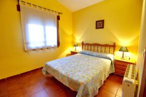 比利亚尔瓦德拉谢拉Aventura & Relax Cabañas Peña la Higuera的黄色的卧室设有床和窗户
