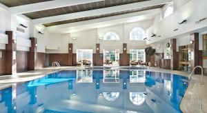 萨顿科尔菲尔德贝尔弗里度假酒店的大楼内的一个蓝色海水游泳池