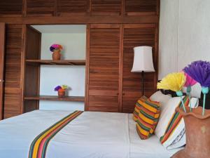 图斯特拉古铁雷斯Hotel Casa Zoque Colonial的卧室配有白色的床和木制床头板