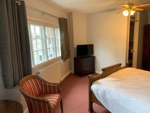 迪韦齐斯卡斯特尔酒店的一间卧室配有一张床、一台电视和一把椅子