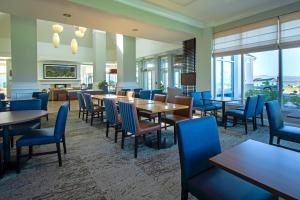 埃尔科Shutters Hotel的餐厅设有桌椅和窗户。