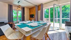 希维拉杜夫-兹德鲁伊Apartament Garden z Sauną Holiday Mountain Residence - 5D Apartamenty的一间带桌椅的用餐室和一间带窗户的房间