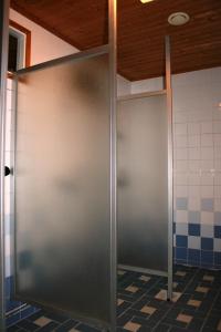 Lohijärvi荒野中心鲑鱼湖酒店的浴室内金属门,铺有瓷砖地板