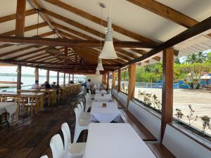 La Herradura巴伊亚德尔索尔酒店的一间设有白色桌子和白色椅子的餐厅