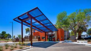埃尔帕索Best Western El Paso Airport Entrada Hotel的停车场内有大玻璃篷的建筑