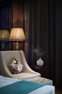 广州鸿德国际酒店的一间卧室配有带枕头和灯的椅子