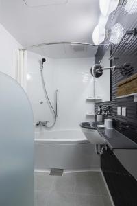 东京KOKO HOTEL Ginza-1chome的浴室配有盥洗盆和浴缸。