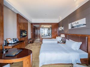 广州鸿德国际酒店的酒店客房配有两张床和一张书桌