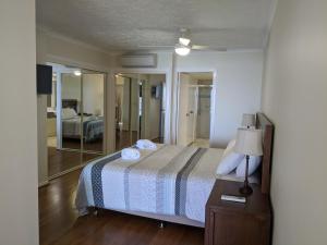 卡伦德拉驳船海滩度假酒店的一间卧室配有一张带灯和镜子的床