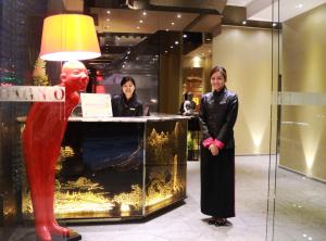 香港Lan Kwai Fong Hotel - Kau U Fong的两个女人站在一个男雕像的柜台前