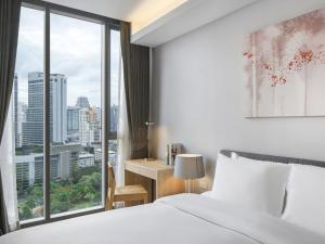 曼谷曼谷橡树套房酒店的酒店客房设有一张床和一个大窗户