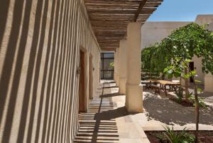 斯代博克Kedma by Isrotel Design的带有树和桌子的建筑走廊