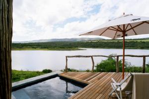 格拉罕镇帕姆巴私人野生动物保护区酒店的一个带遮阳伞的游泳池和一个美景甲板