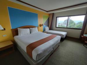 合艾斯格黄金酒店的酒店客房设有两张床和窗户。