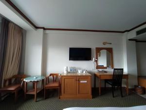 合艾斯格黄金酒店的酒店客房配有书桌和带镜子的桌子