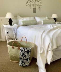 绍斯布鲁姆珊瑚树殖民地住宿加早餐酒店的卧室配有一张大白色床和篮子