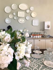 绍斯布鲁姆珊瑚树殖民地住宿加早餐酒店的厨房配有一张带白色花卉和盘子的桌子。