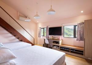 鹿谷乡名竹旅社 Minzu Hotel的一间卧室配有两张床、一张桌子和一台电视。
