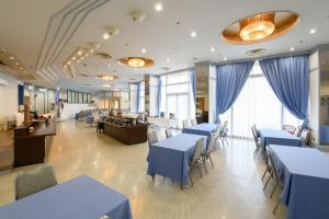 烧津市Hotel Tetora Resort Shizuoka Yaizu的一间配备有蓝色桌椅的用餐室