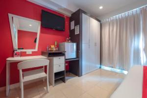 芭堤雅市中心Access Inn Pattaya的一间卧室设有红色的墙壁、书桌和镜子