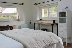CrothLe Chemin du Village的卧室配有一张床、一张书桌和窗户。