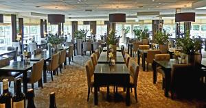 斯霍尔简凡斯克罗尔弗莱彻酒店的餐厅设有桌椅和瓶装葡萄酒
