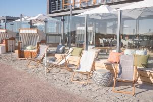 圣彼得奥尔丁斯特兰德古特度假酒店的海滩上的一组椅子和遮阳伞