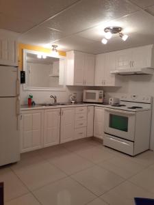 圣费利西安贝尔维尤公寓的厨房配有白色橱柜和白色家电