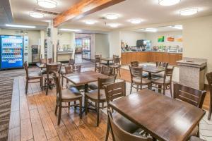 卡纳布Quality Inn Kanab National Park Area的餐厅设有木桌、椅子和柜台