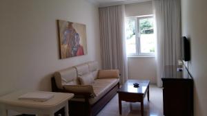 格罗韦Apartamentos Maritimo Suites-Solo Adultos的客厅配有沙发和桌子