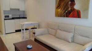 格罗韦Apartamentos Maritimo Suites-Solo Adultos的客厅配有沙发和墙上的绘画