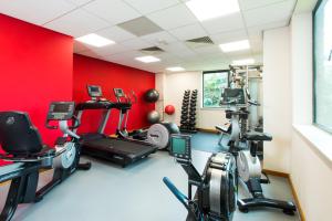 比肯希尔ibis Styles Birmingham NEC & Airport的健身房设有心肺功能训练器材和红色墙壁