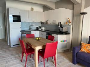 巴特Speicher Residenz Barth E3 App 1的厨房配有木桌和红色椅子