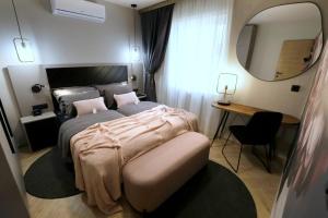 巴什卡沃达维利卡公寓式酒店的一间卧室配有一张床、镜子和一张书桌