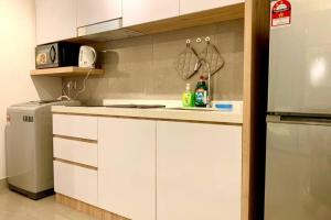 马六甲Imperio,Res - Melaka Raya -- Comfy -- Sunset View的厨房配有白色橱柜和冰箱。