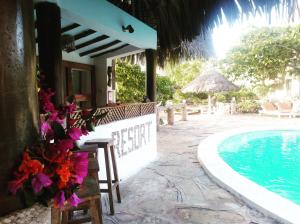 马林迪Flamingo Villas Resort的一个带游泳池和桌椅的度假村