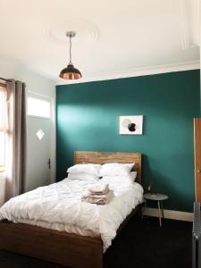 MoortownNewly refurbished apartment in Chapel Allerton, Leeds的一间卧室设有绿色的墙壁和一张床