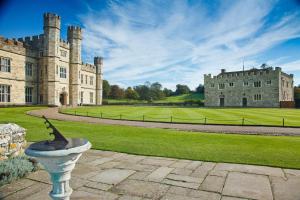 梅德斯通Leeds Castle Maiden's Tower的一座大城堡,前面有雕像