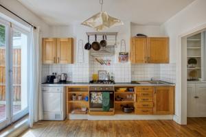 伦敦Pass the Keys - Beautiful stylish flat in South West London的厨房配有木制橱柜和炉灶烤箱。